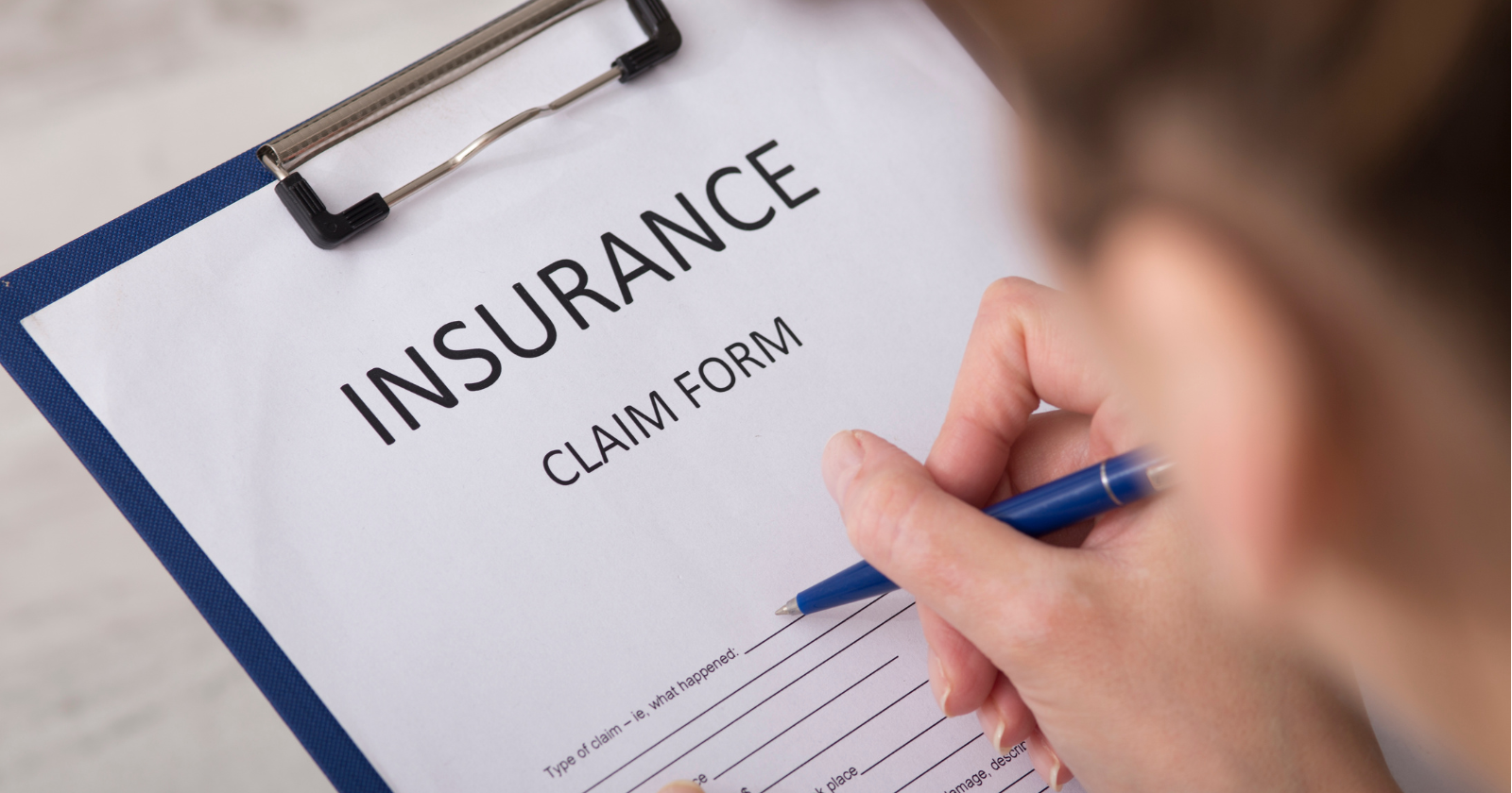 A person filling out an insurance claim form