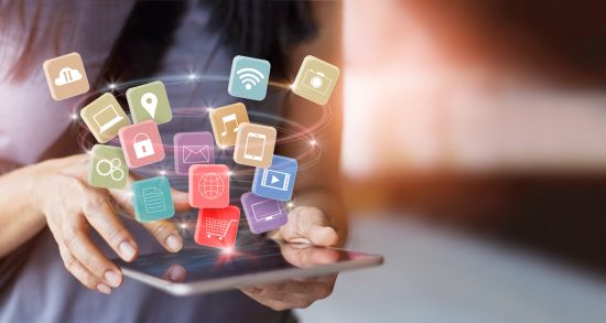 person holding an ipad and the app icons circle up and out of the ipad