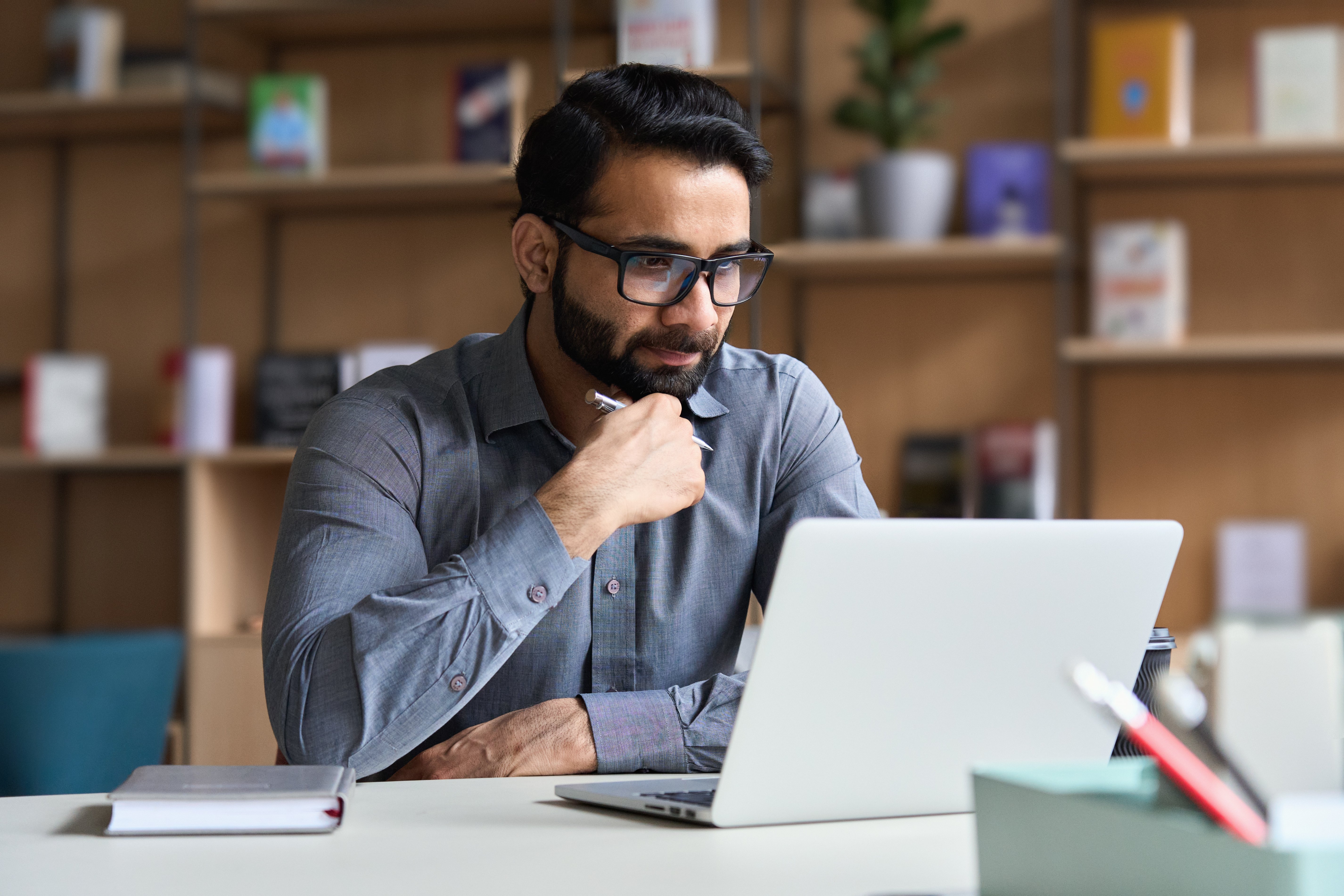 male with glasses looking at computer screen